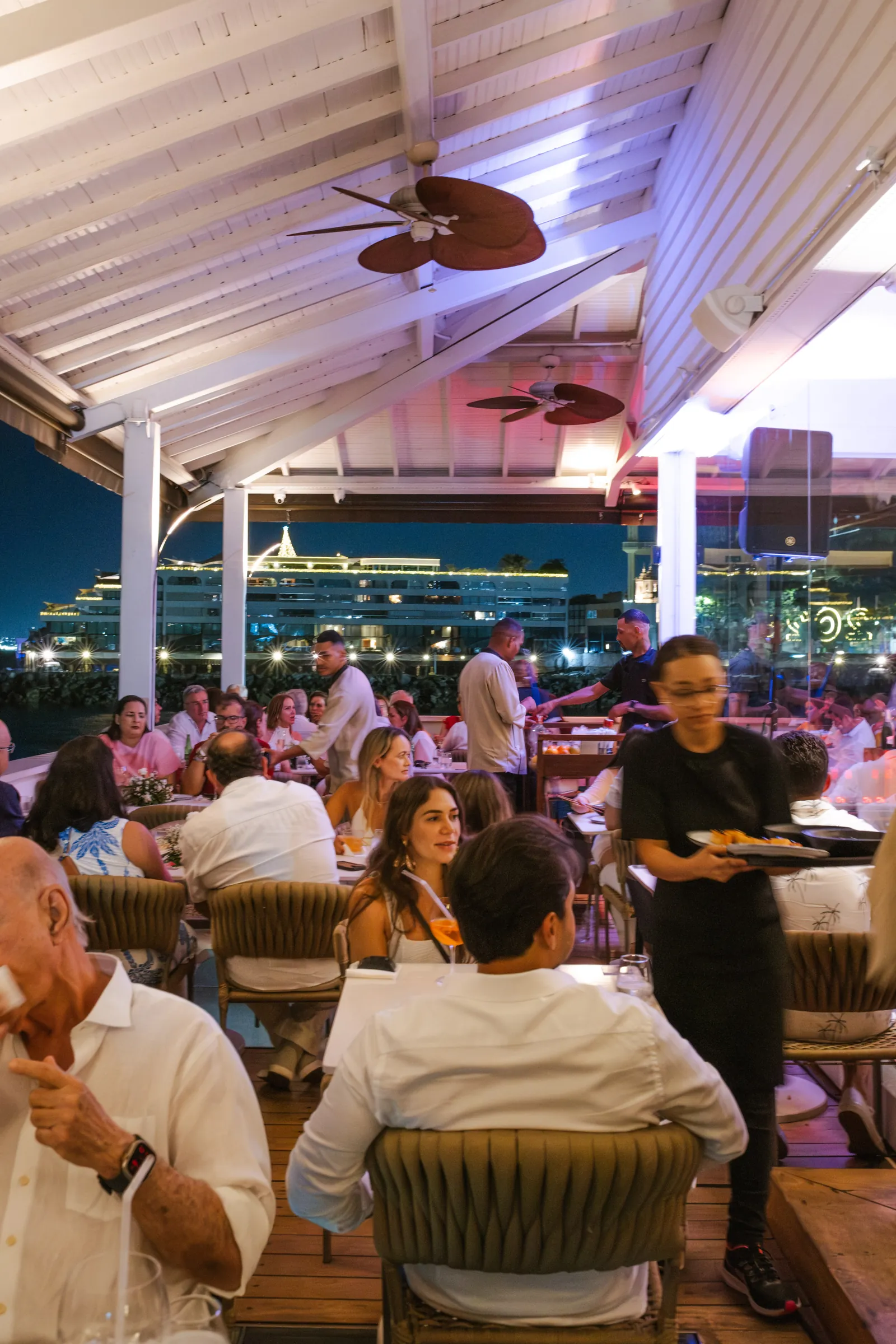 Salão do Soho Bahia Marina à noite, com vista para a marina